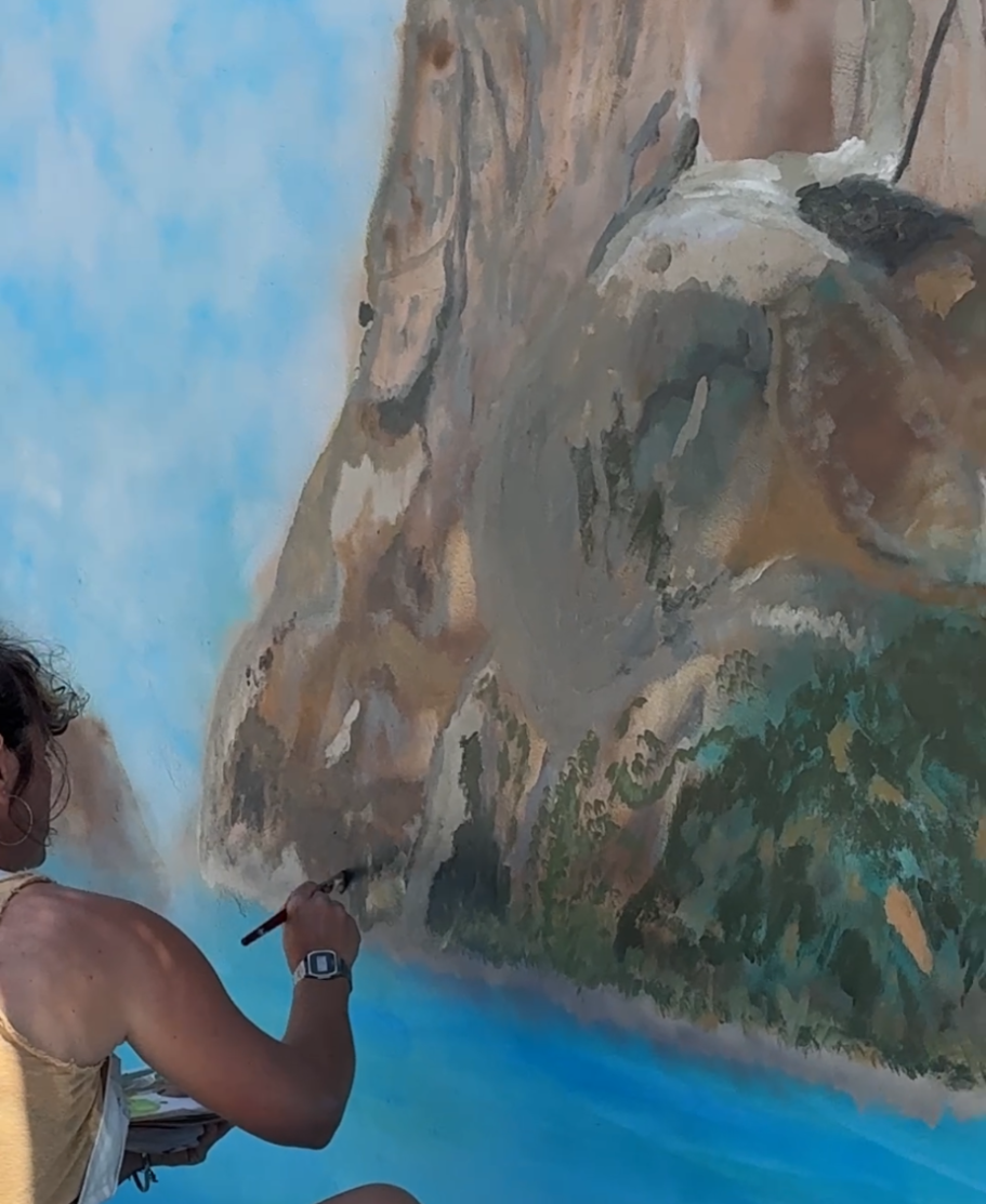 Manos a la obra pintando el mural encargado